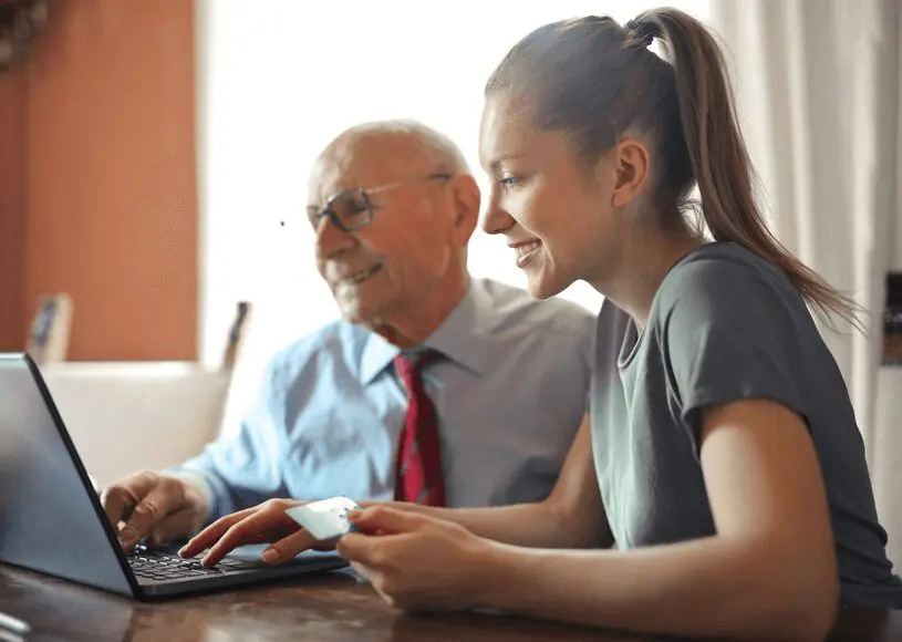 Two people smiling at a computer screen