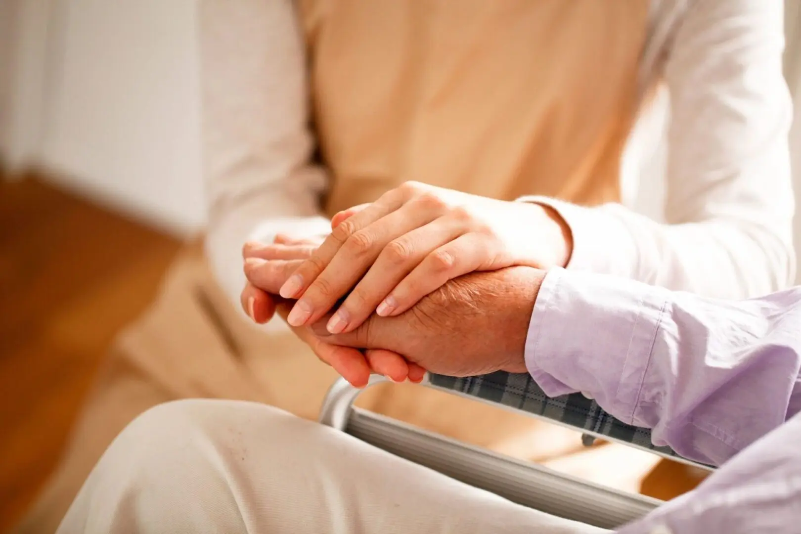 Caring hands on wheelchair