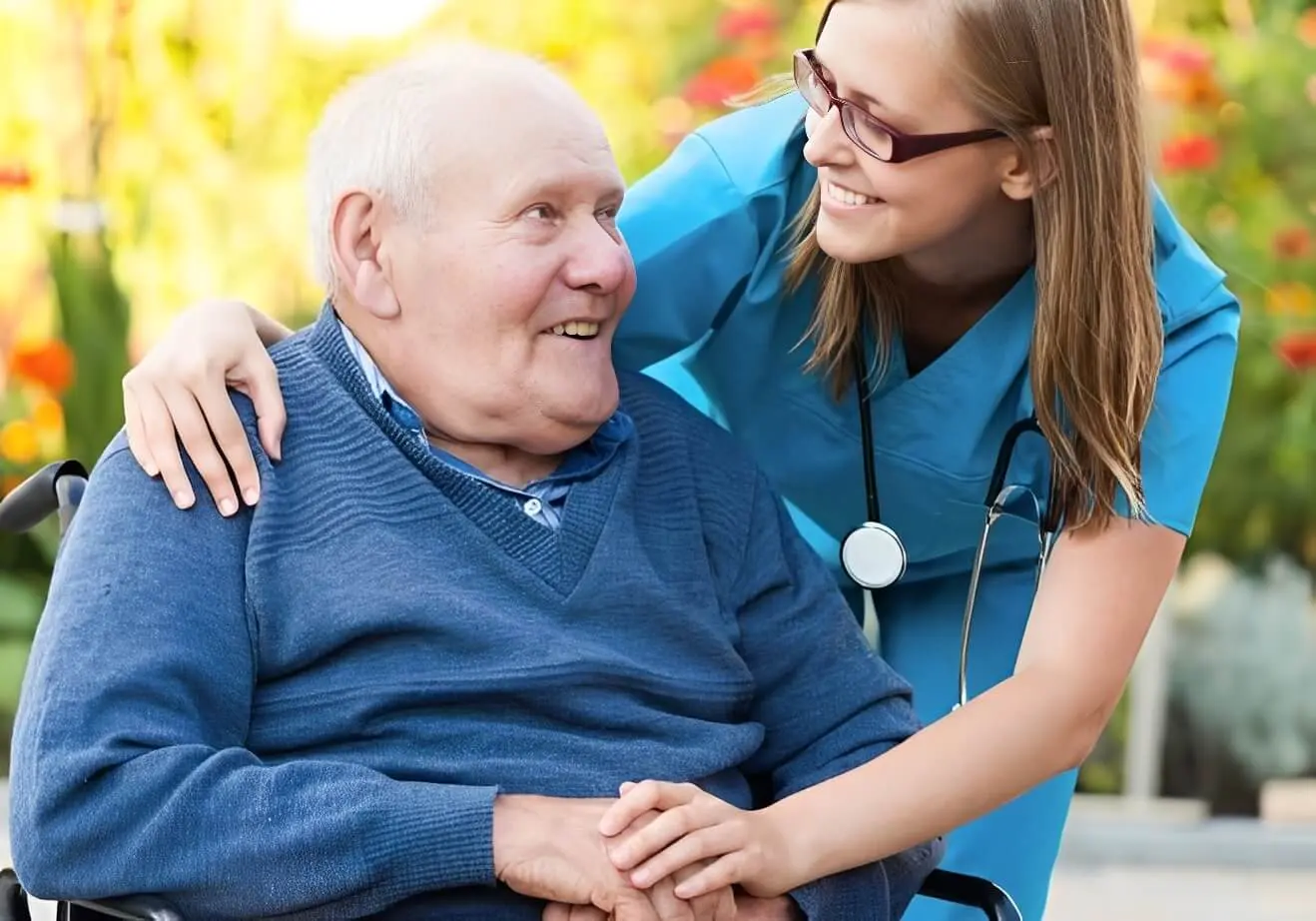 Nurse smiling with elderly patient in wheelchair