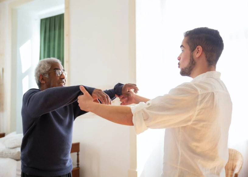 Elderly man exercising with assistance