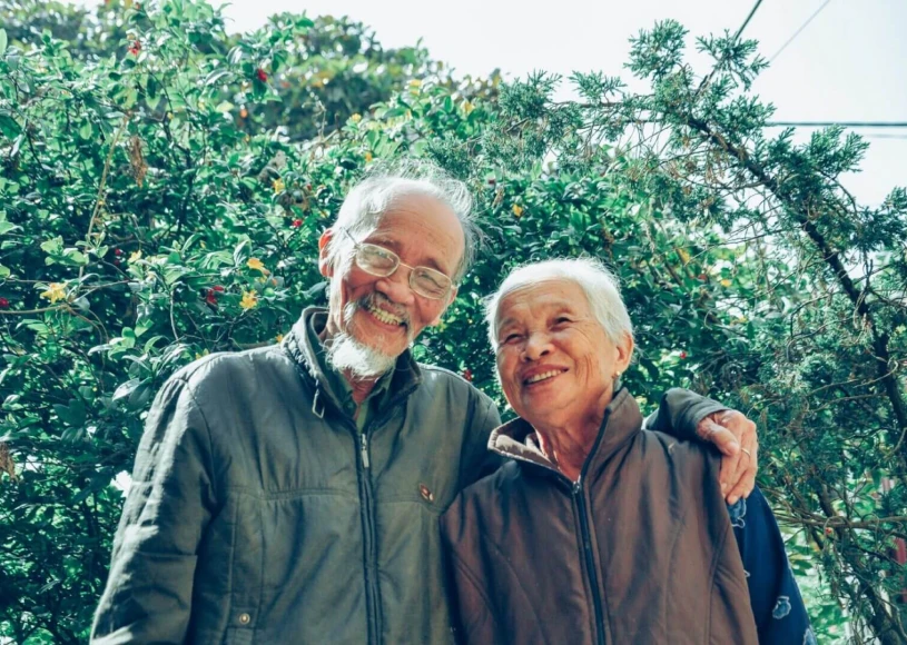 Elderly couple smiling in garden