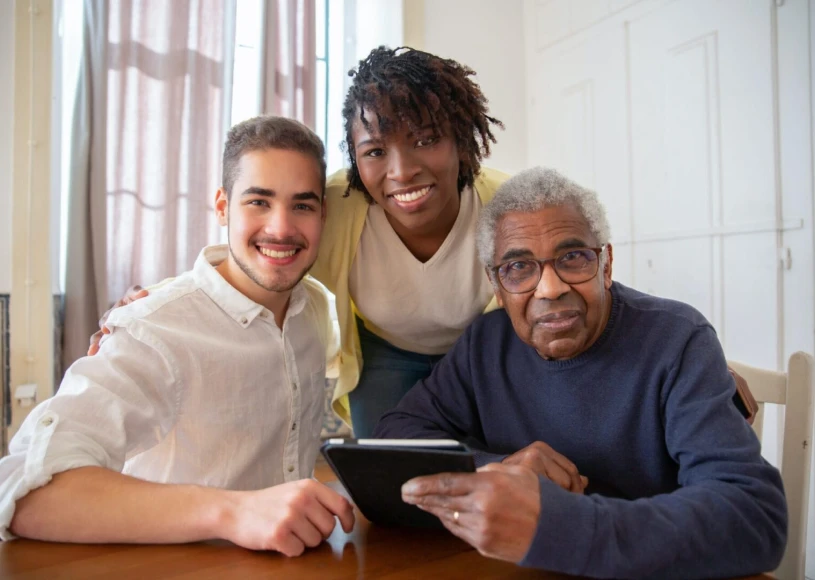 Three people smiling with a tablet
