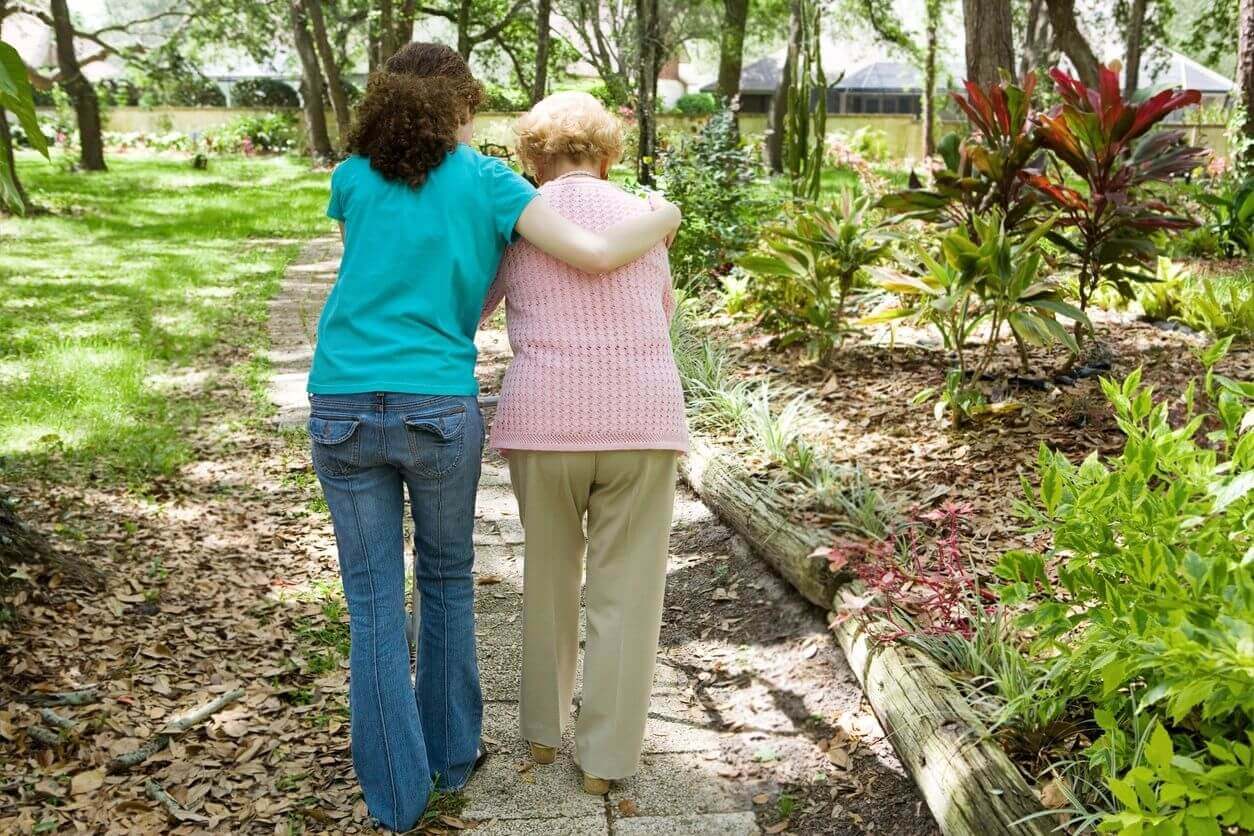 Two women walking in a lush garden