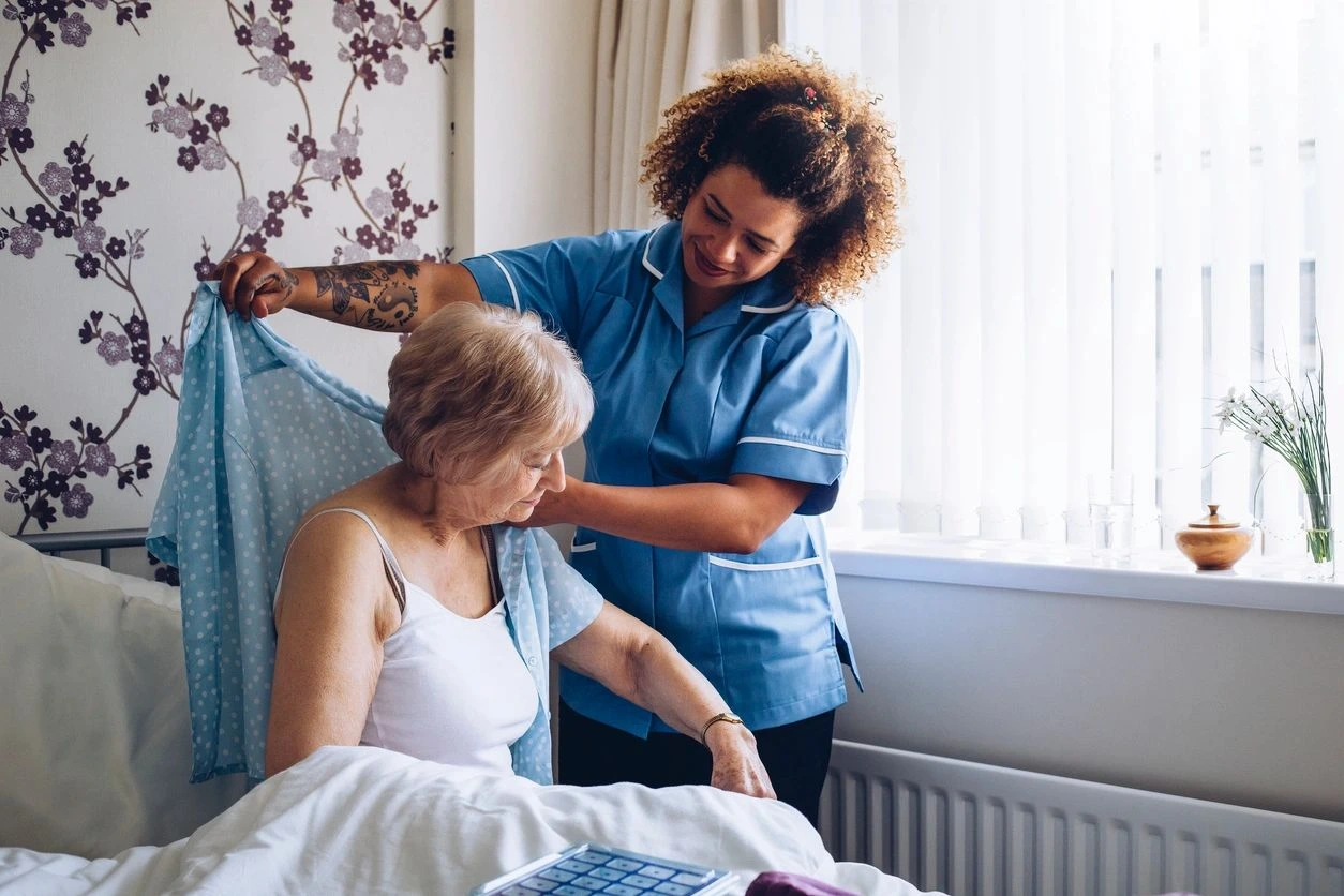 Healthcare worker supporting elderly patient at home