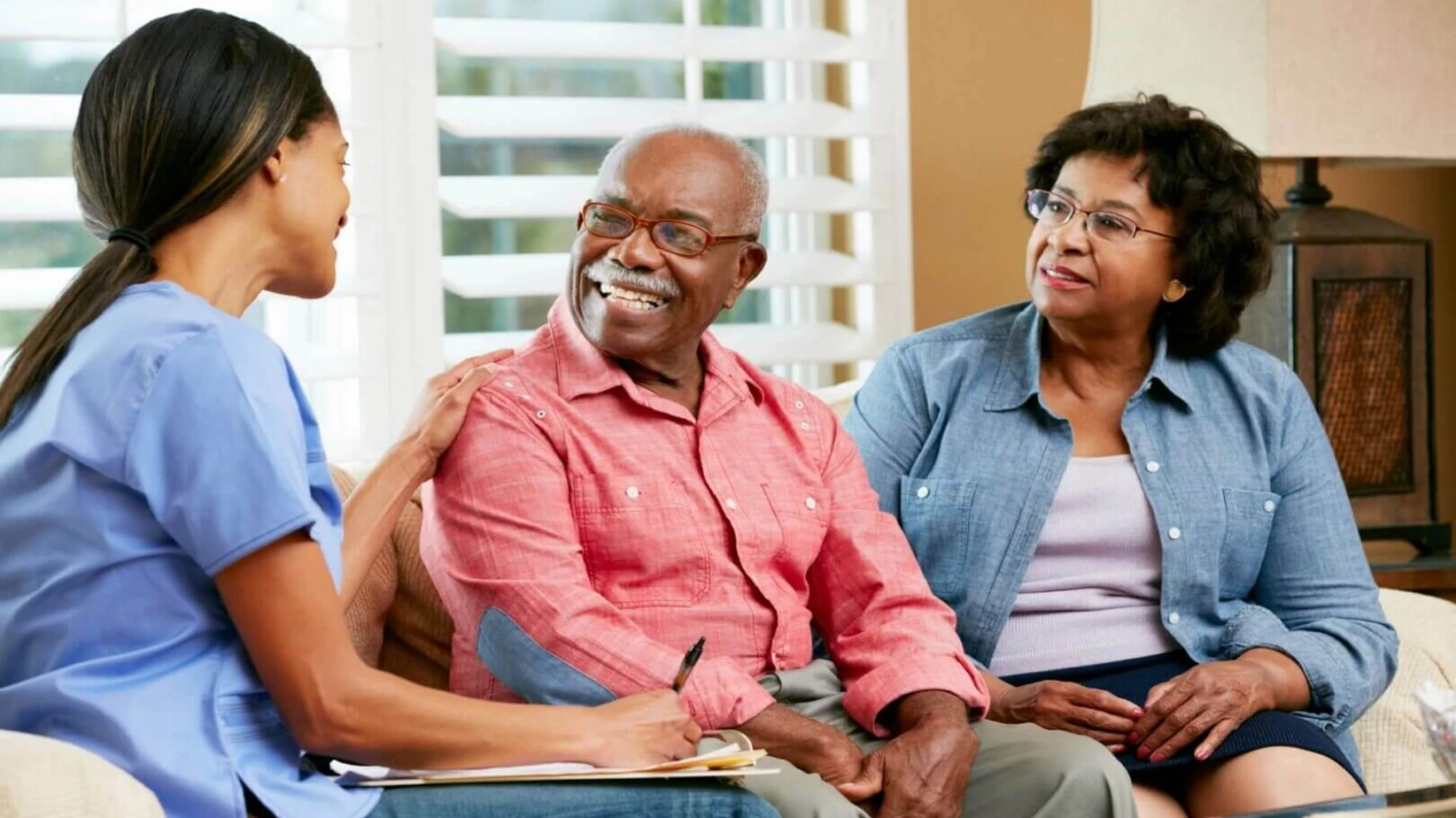 Healthcare discussion with elderly couple on couch