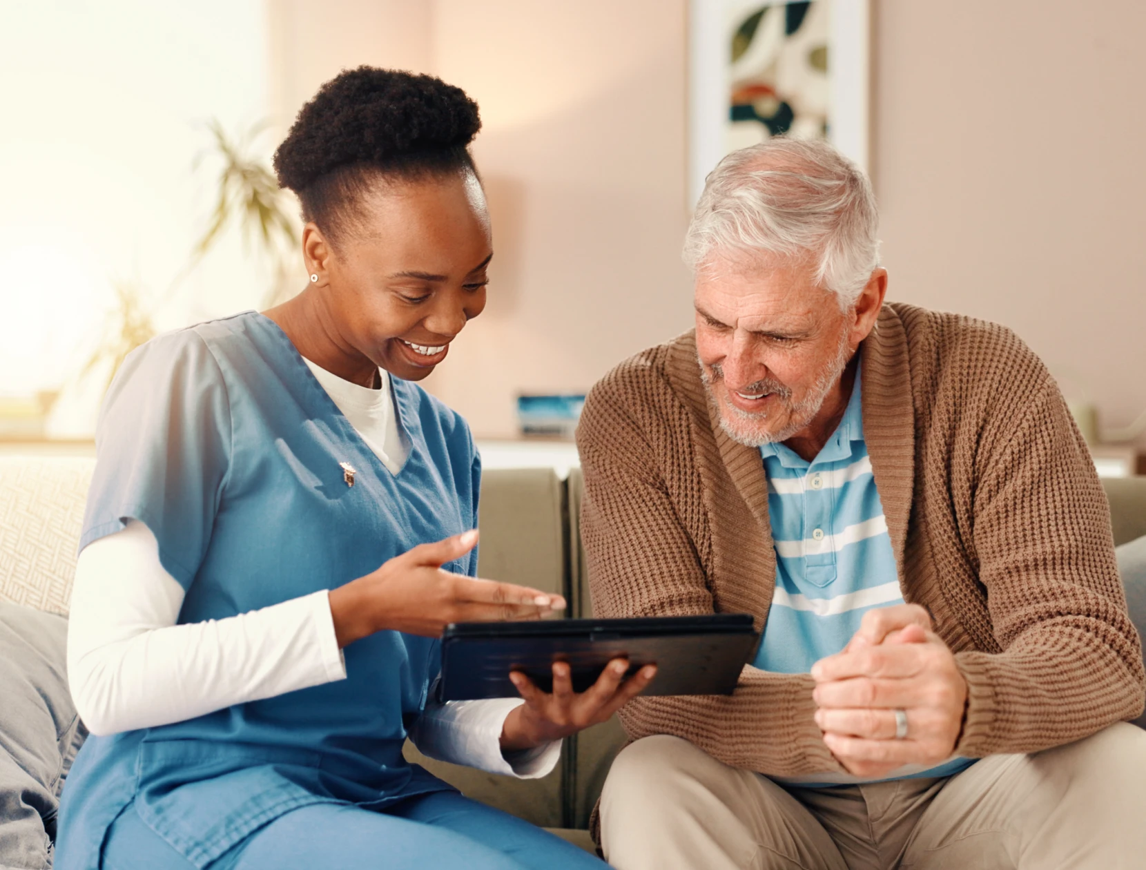 Nurse and senior man using tablet