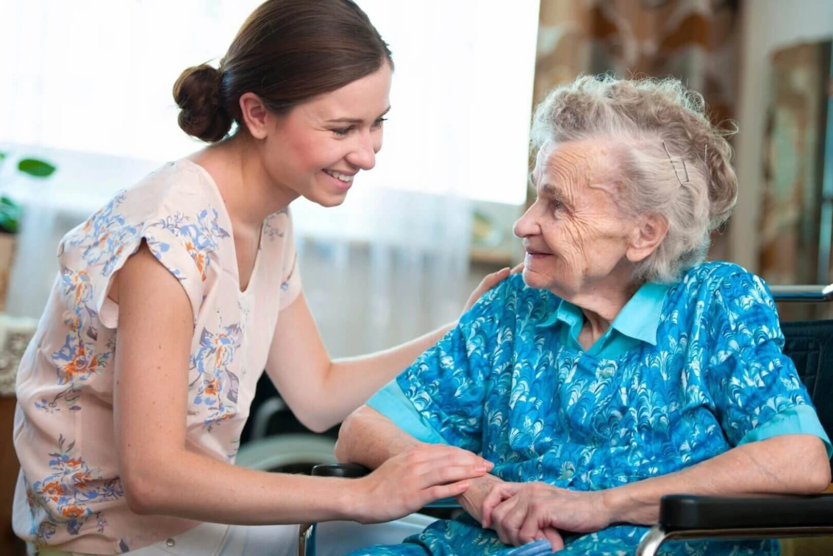 Young woman comforting elderly lady.